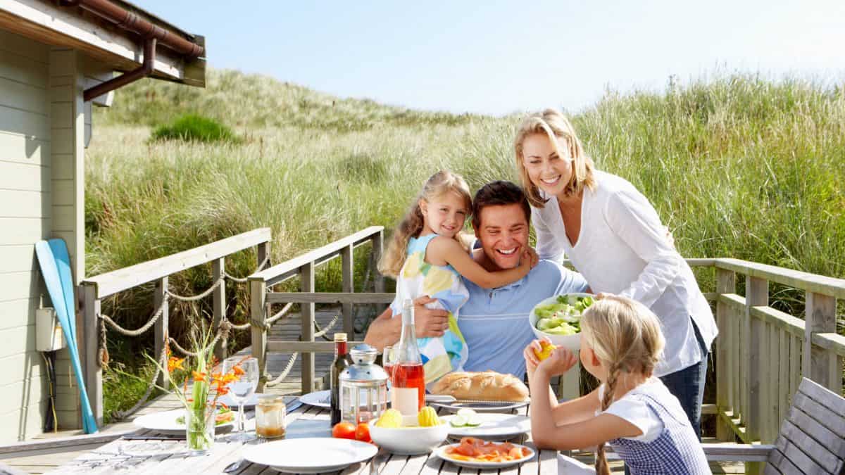 Familie buiten aan het eten bij hun vakantiehuisje
