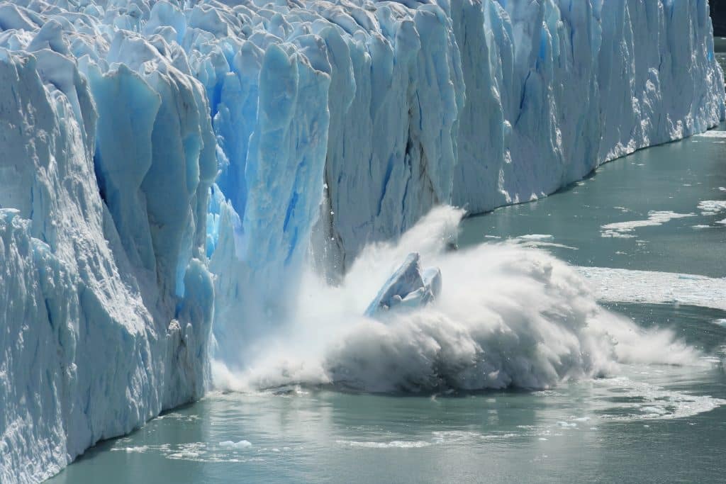 stuk ijs valt in het water op antarctica Stuk ijs valt in het water op Antarctica