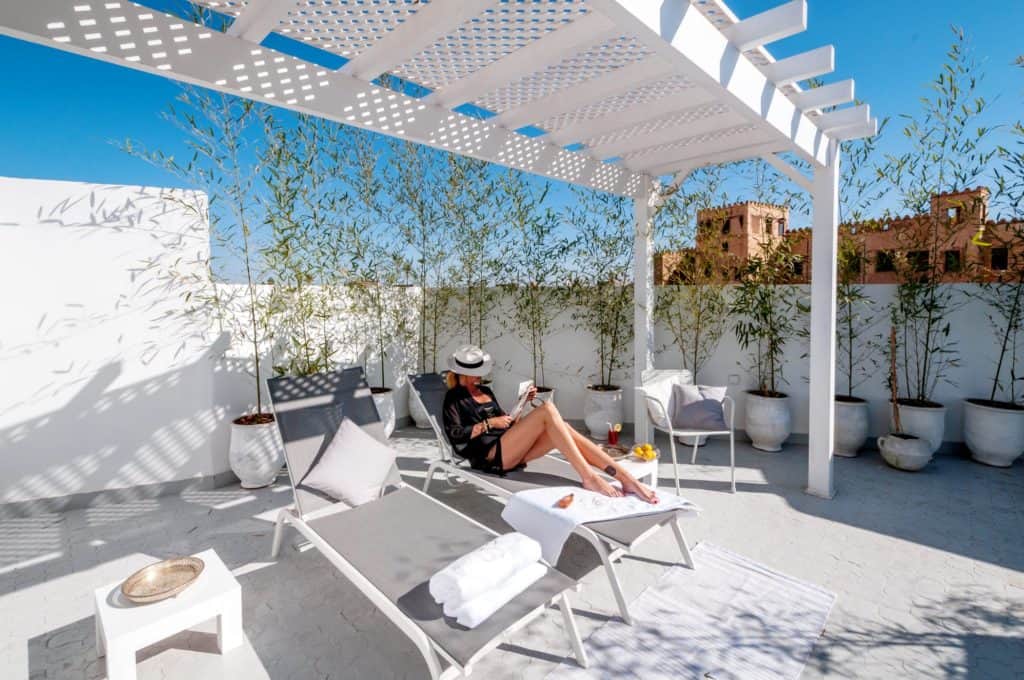 ligbed zwembad riad dar grawa in marrakech marokko Vrouw op ligbed bij het zwembad van Riad Dar Grawa in Marrakech, Marokko
