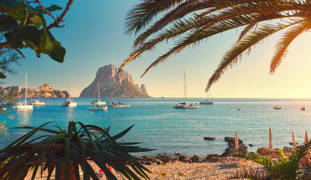 strand cala d hort ibiza met zeilboten zee uitzicht es vedra Strand van Cala d’Hort op Ibiza met zeilboten op zee en uitzicht op Es Vedra