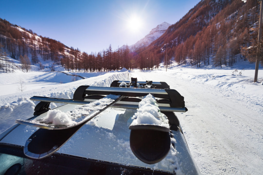 besneeuwde ski s bovenop auto Besneeuwde ski's bovenop een auto