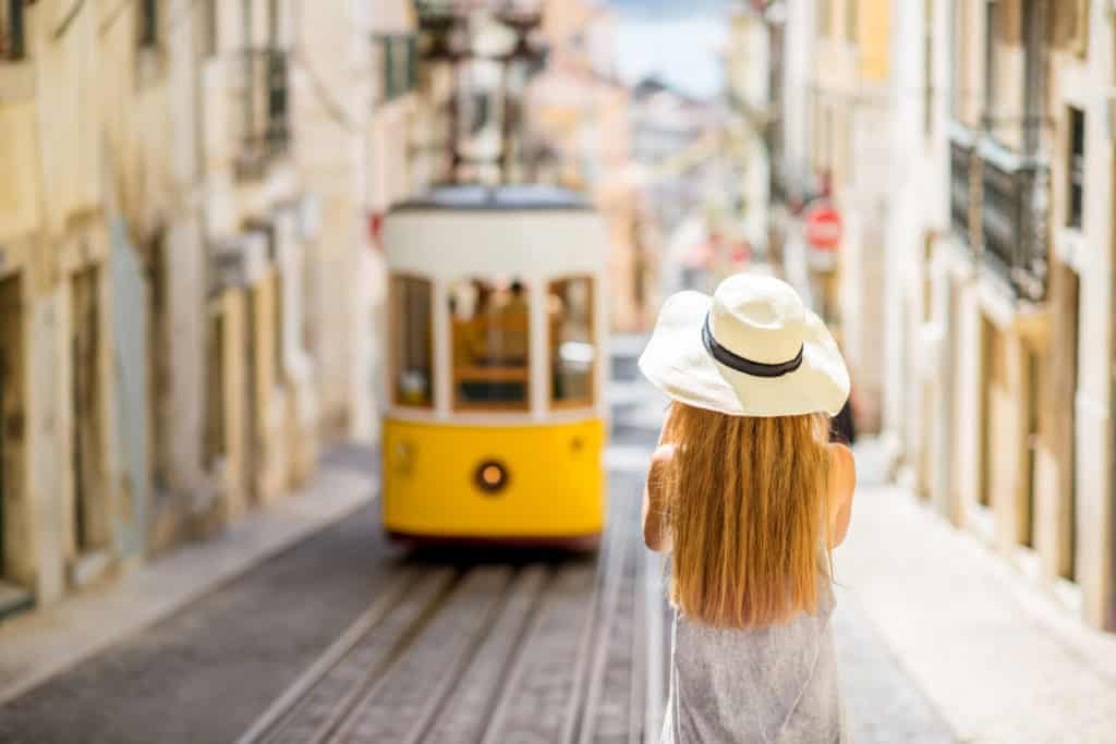 vrouw met hoed kijkt naar bekende gele tram lissabon portugal vrouw met hoed kijkt naar bekende gele tram lissabon portugal