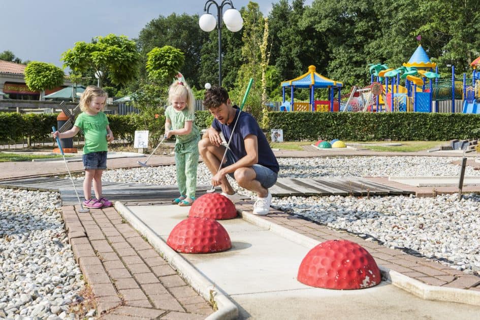 vader kinderen midgetgolf roompot resort arcen in arcen limburg nederland Vader met kinderen aan het midgetgolfen op Roompot Resort Arcen in Arcen, Limburg, Nederland
