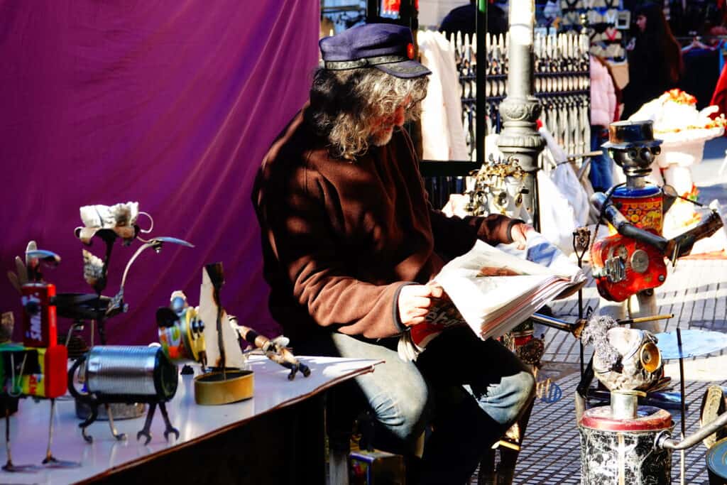 man leest krant el rastro markt madrid spanje Man leest krant op de El Rastro markt in Madrid, Spanje