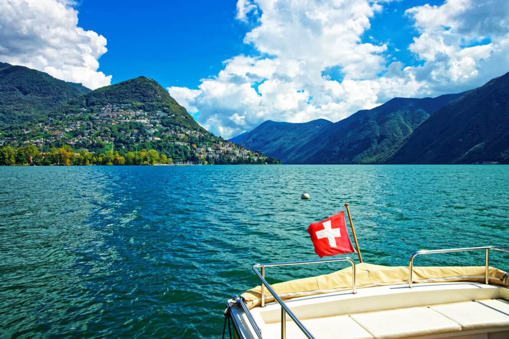 zwitserse vlag meer van lugano Boot met Zwitserse vlag op het meer van Lugano