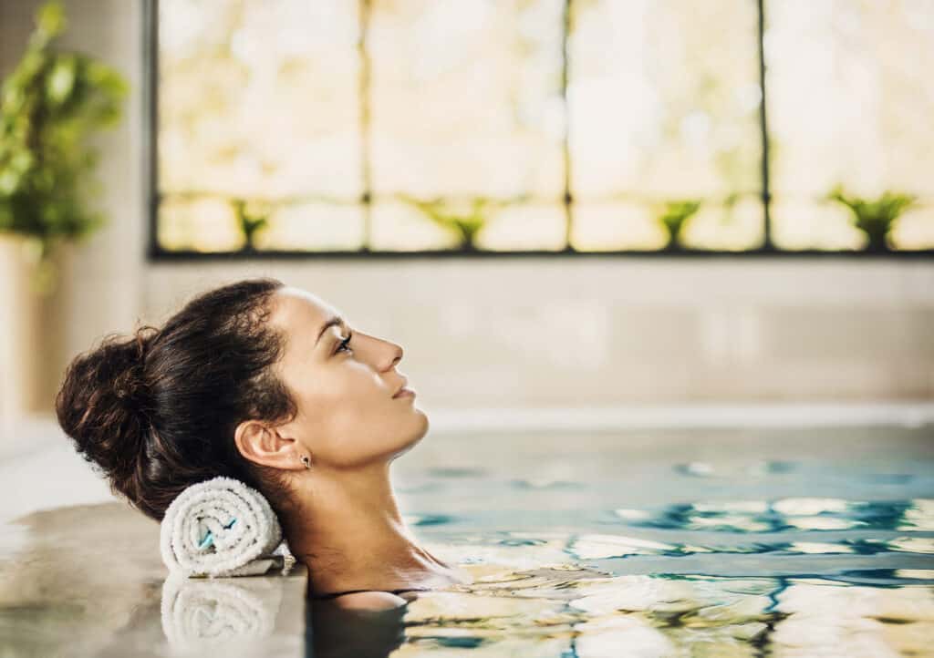 vrouw ligt ontspannen zwembad wellness center Vrouw ligt ontspannen in een zwembad van een wellness center