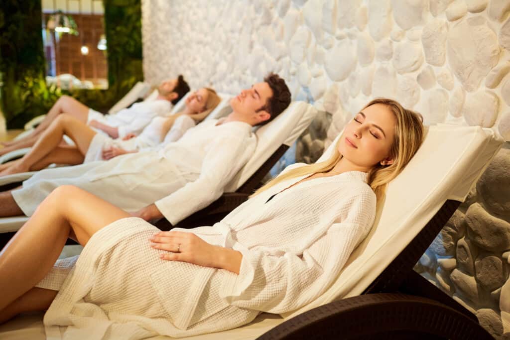 mensen badjassen rusten relaxruimte wellness Mensen in badjassen rusten in de relaxruimte van de wellness