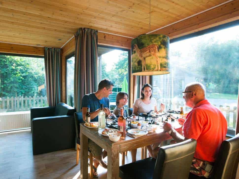 familie is gezellig samen aan eten huisje vakantiepark dierenbos Familie is gezellig samen aan het eten in een huisje van Vakantiepark Dierenbos