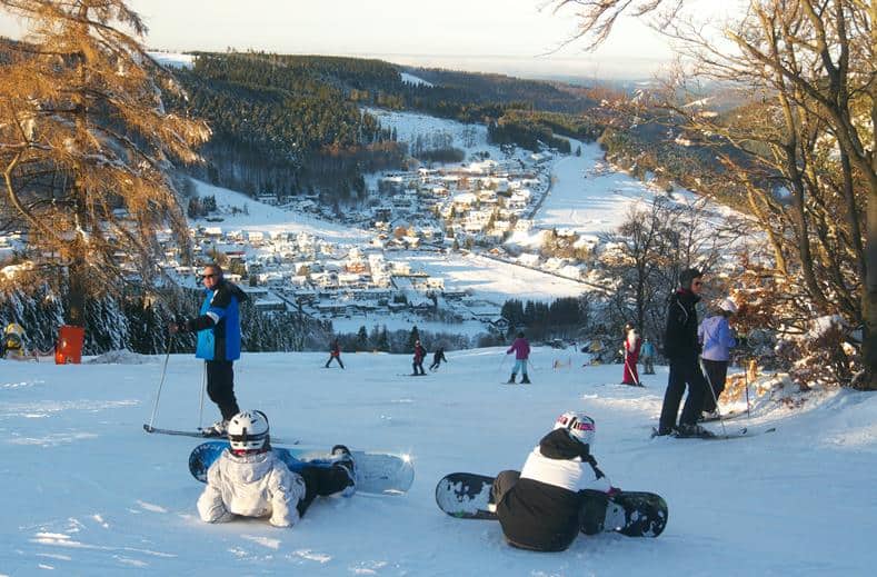 snowboarders skiers piste met uitzicht willingen duitsland Snowboarders en skiërs op de piste met uitzicht op Willingen, Duitsland