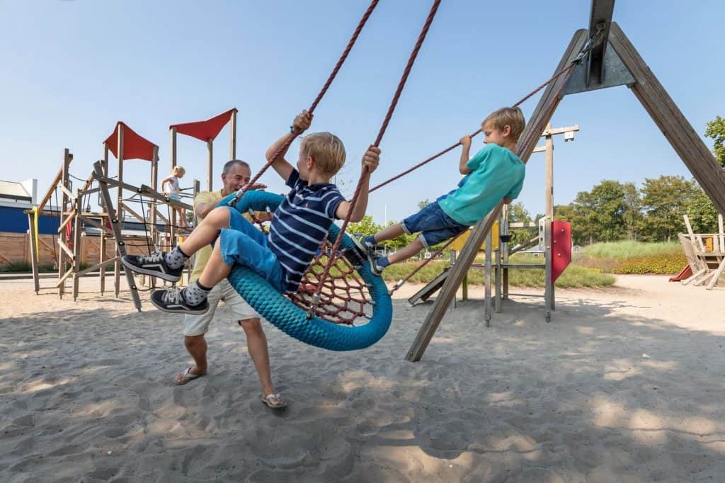vader speeltuin met twee kinderen Vader in de speeltuin met twee kinderen