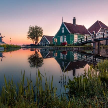 Huis bij een kanaal met een molen in Noord-Holland