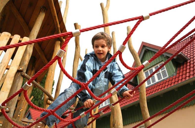 jongen klimt klimrek Jongen klimt in een klimrek