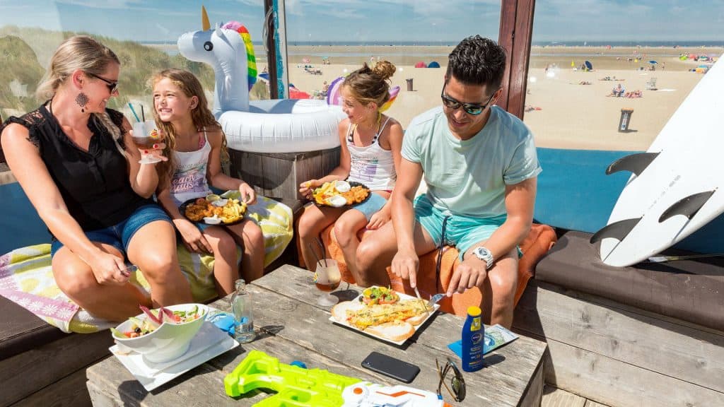 familie aan eten strandtent bij zee Familie aan het eten in een strandtent bij zee