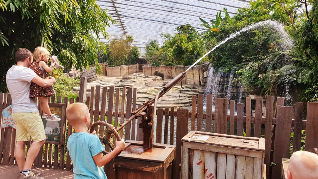 kind speelt met waterspuit bij olifanten jungola Kind speelt met waterspuit bij de olifanten in Jungola