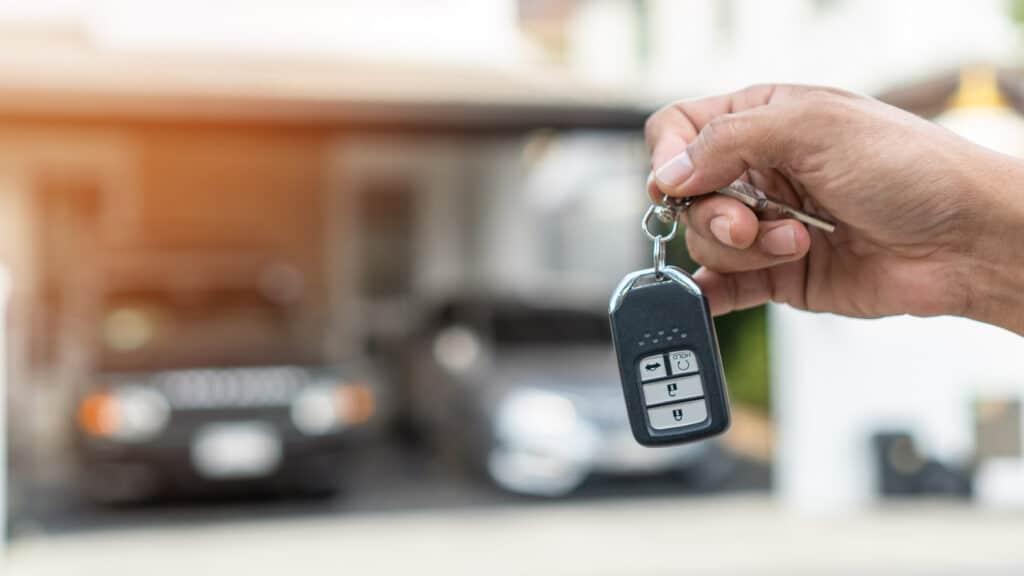 hand houdt autosleutel vast Hand houdt autosleutel vast