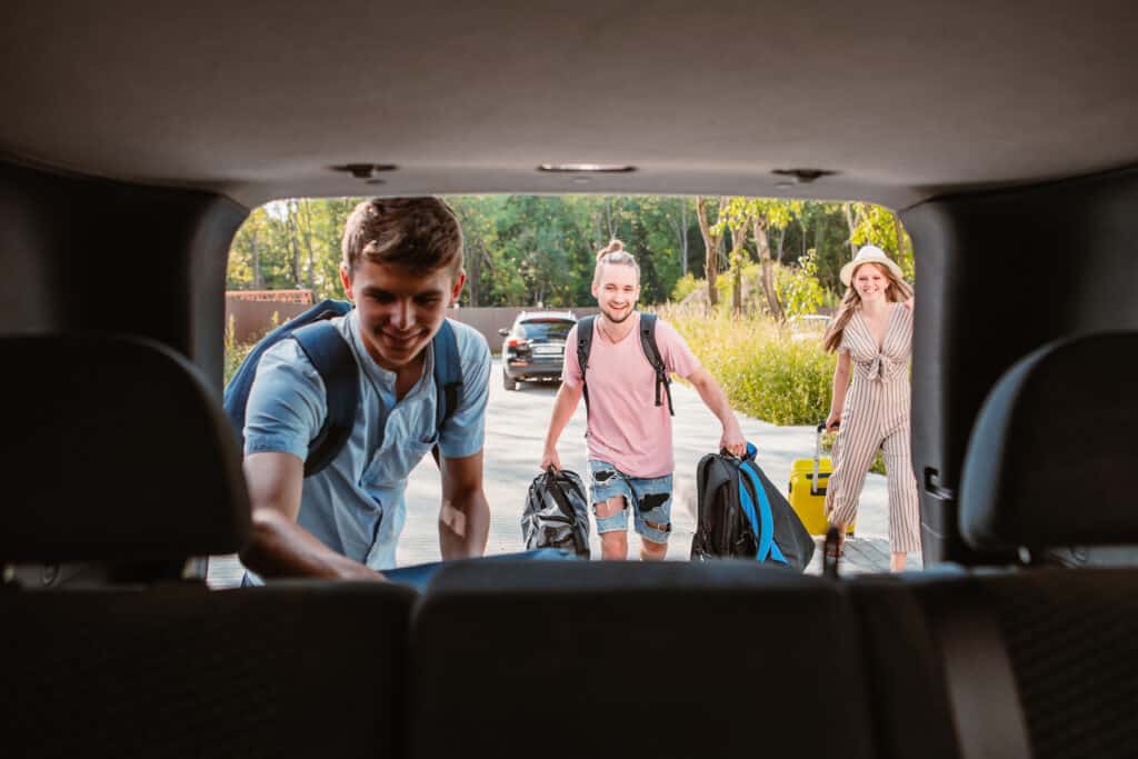 vrienden laden de achterbak van een auto in Vrienden laden de achterbak van een auto in