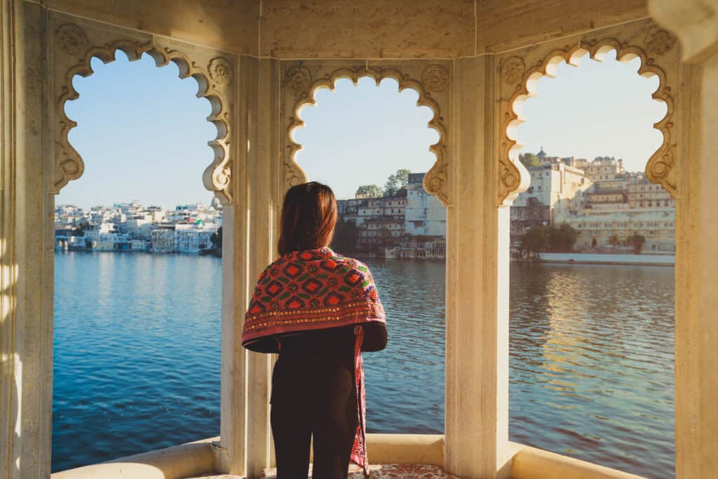 vrouw kijkt uit over het pichola meer in rajasthan india Vrouw kijkt uit over het Pichola meer in Rajasthan, India