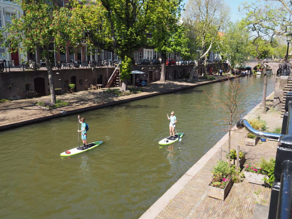 twee mensen aan het suppen op het kanaal in utrecht Twee mensen aan het suppen op het kanaal in Utrecht