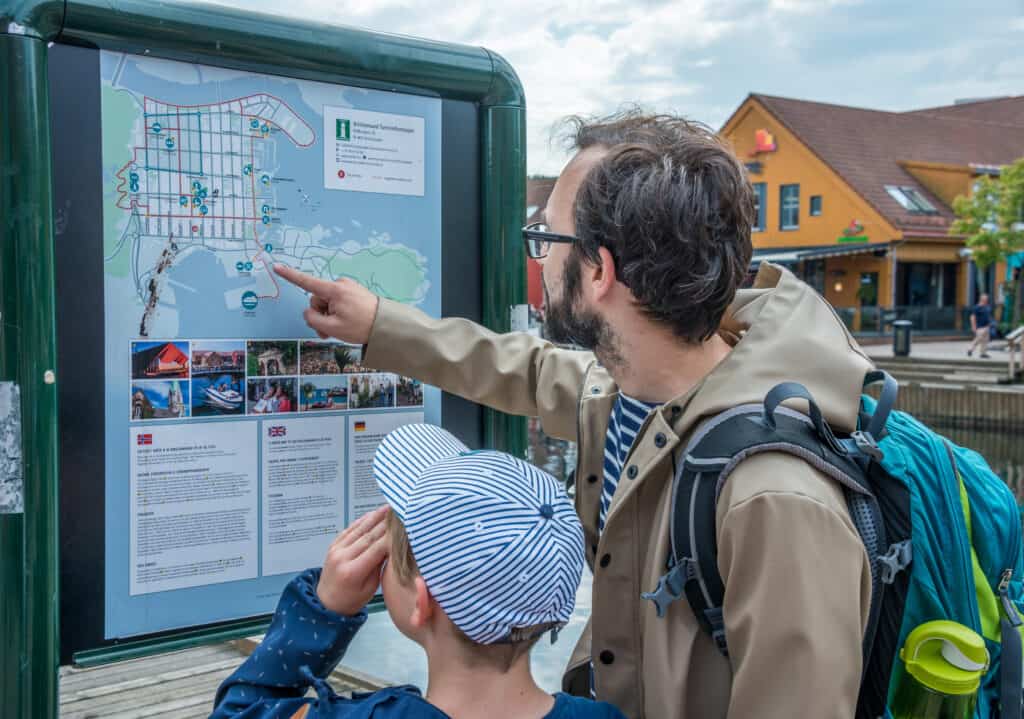 toeristen kijken naar een plattegrond van kristiansand in noorwegen Toeristen kijken naar een plattegrond van Kristiansand in Noorwegen