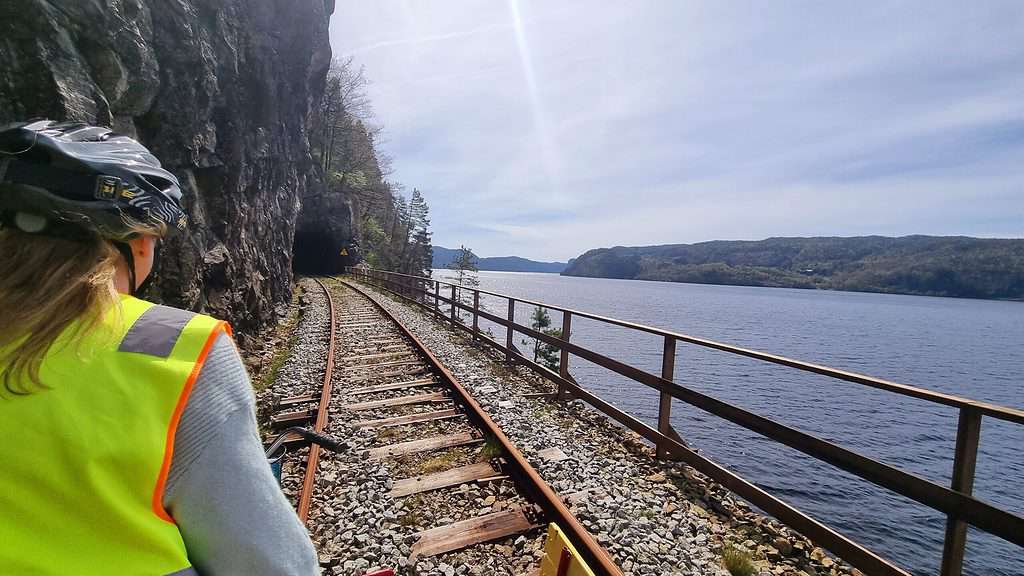 op de fiets van de flekkefjordbanen langs een meer en richting een tunnel Op de fiets van de Flekkefjordbanen langs een meer en richting een tunnel